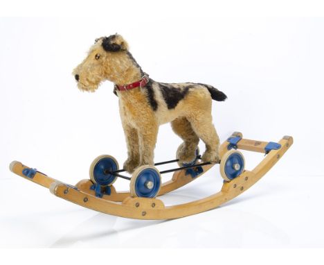 A post-war Steiff Terry Airedale terrier on wheels and rocker,  of brown and black mohair, glass eyes, pull cord growler, scr
