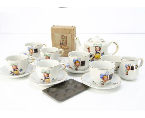 A child's tea set printed with googly eyed child and Golly, six cups and saucers, tea pot -4in. (10cm.) high, sugar bowl (chi