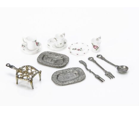 Earlier dolls' house chattels,  three milk glass cups and saucers painted with roses; a soft metal trivet --1¾in. (4.5cm.) lo
