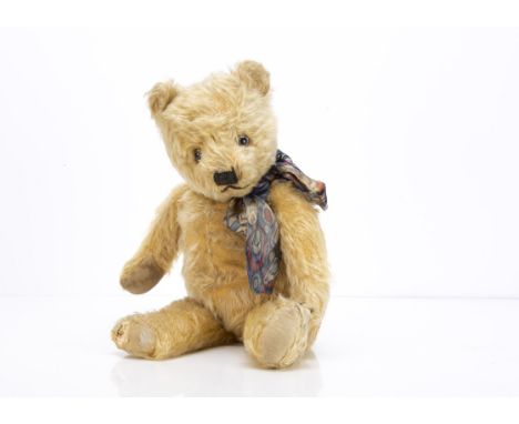 A 1930s Chiltern-type teddy bear,  with golden mohair, clear and black glass eyes with brown painted backs, pronounced muzzle