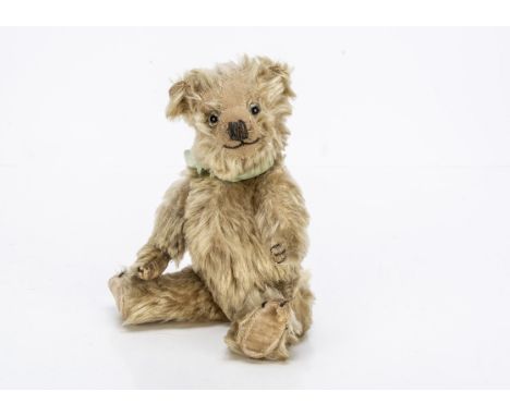 A small 1930s Chiltern Hugmee teddy bear, with blonde mohair, clear and black glass eyes, pronounced clipped muzzle, black st