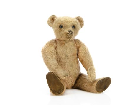 An early J K Farnell teddy bear circa 1920, with pink mohair, black boot button eyes, pronounced muzzle, remains of black sti