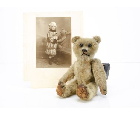 A German teddy bear 1910-1920s,  with blonde mohair, black boot button eyes, black stitched nose, mouth and claws, slotted in