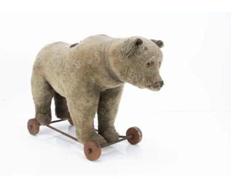 A Steiff bear on wheels circa 1920,  with brown mohair, clear and black glass eyes with brown backs, pronounced muzzle, remai