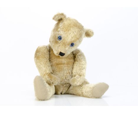 A post-war Chiltern Hugmee teddy bear,  with blonde mohair, replaced blue plastic eyes, black stitched nose and mouth, swivel