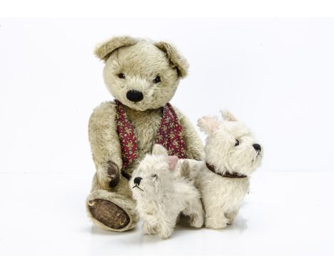 A post-war Chad Valley teddy bears and two white terriers, the bear with blonde mohair, orange and black glass, pronounced mu