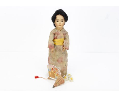 A German bisque-headed Oriental doll marked 164,   either Simon &amp; Halbig or Schoenau &amp; Hoffmeister with brown sleepin