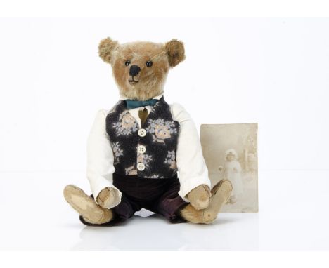 A Steiff teddy bear with photograph of the original owner,  with blonde mohair, black boot button eyes, pronounced muzzle, re