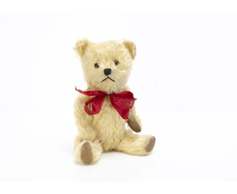 A post-war Chiltern Hugmee teddy bear,  with blonde mohair, orange and black glass eyes, black stitched nose and mouth, swive