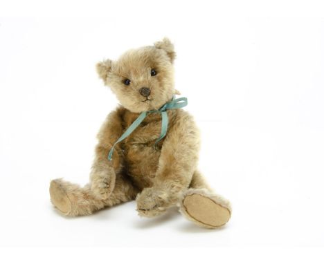 An early Steiff teddy bear with blank button,  with blonde mohair, black boot button eyes, pronounced muzzle, black stitched 