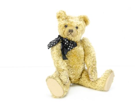 A fine J K Farnell teddy bear circa 1920,  with blonde mohair, clear and black glass eyes with remains of brown painted backs