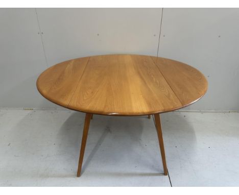 An Ercol elm oval drop leaf dining table, width 124cm extended, height 71cm, together with five Ercol elm, ash and beech dini