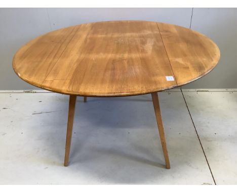 An Ercol circular elm and beech drop flap dining table, diameter 112cm, height 71cm, and four Ercol chairs. Condition - fair