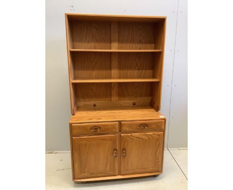 An Ercol Windsor elm side cabinet, width 91cm, depth 43cm, height 160cm. Condition - good The shelves have grooves for the di