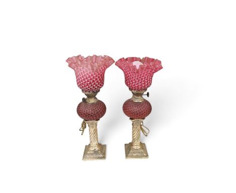 A pair of electroplate and ruby glass oil lamps, 35cm. Condition - good, not tested as working Silver plate with light dents,