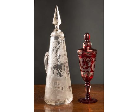 A ruby glass goblet and cover with clear carved bird and swirling decoration, the cover with faceted finial, 26cm high togeth