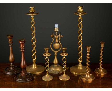 A pair of turned mahogany candlesticks 27cm high; a pair of bell metal candlesticks of spiral form, 23cm high; two pairs of b