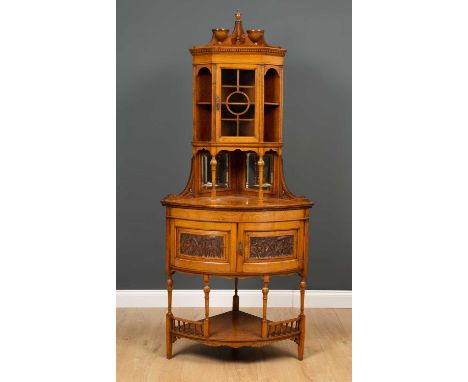 A Victorian oak corner display cabinet with carved urn finial and breakscroll pediment over astragal glazed door flanked by s