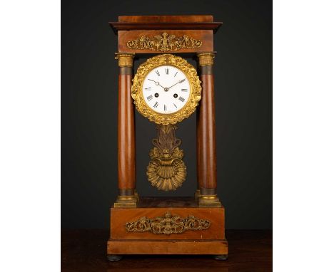 A 19th century French empire style walnut Portico mantle clock the enamelled dial with roman numerals, overall 27cm high x 16