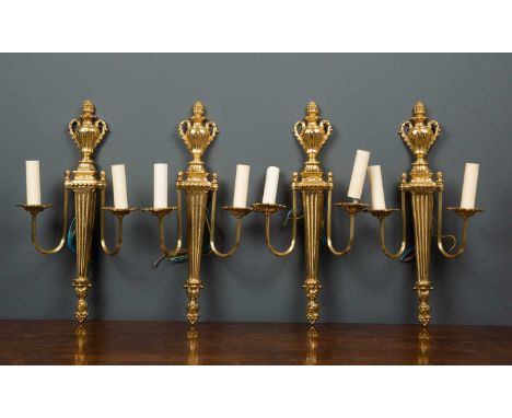 A set of four late 20th century gilt metal twin branch wall lights of classical urn and column form, each 26cm wide x 49cm in