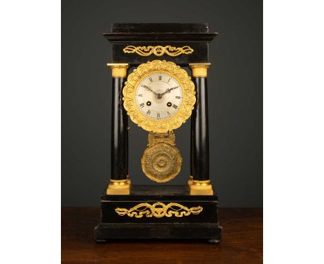 A 19th century French empire style ebonised wood Portico clock the silvered dial with roman numerals and engine turned decora