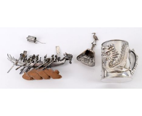 
	
		A Chinese white metal dragon tankard, unmarked, with monogram, 7.5cm high; a Chinese white metal model of a boat, unmark