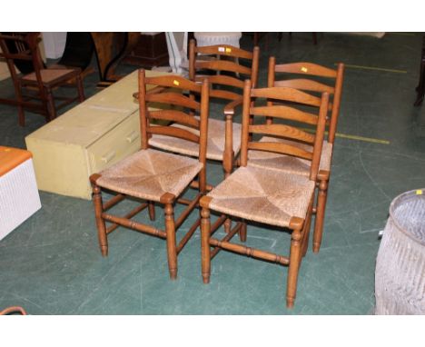 Four oak rush seat ladder back chairs and carver armchair
