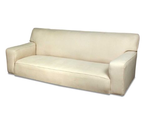 Betty Joel (1894-1985), a large cream upholstered modernist sofa, with squared arms and raised on casters84 x 230 x 90cmProve