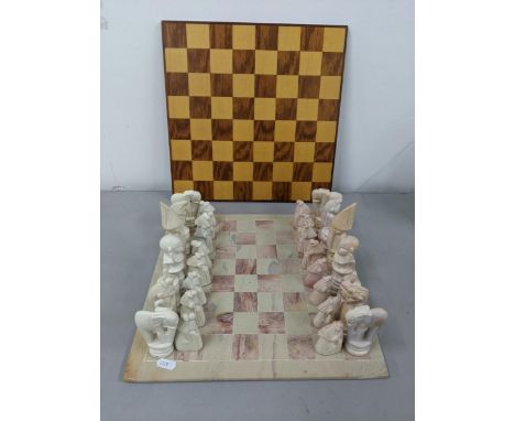 A soapstone chess board having engraved chess pieces, along with a wooden chessboard Location: 