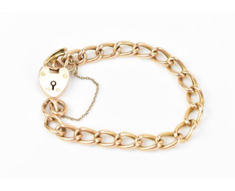 A yellow metal curb link bracelet, with heart padlock clasp and safety chain, weight 14.5 gramsLocation: 