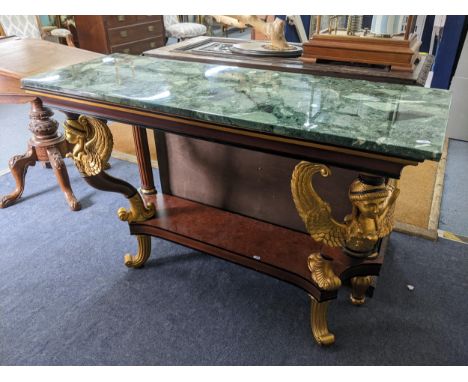 An Empire style rectangular topped console table having a marble effect top supported by two winged angels and a shelf below,