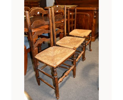 A pair of ash ladder-back chairs, rushed seats, turned legs and rails, and a companion similar chair. 