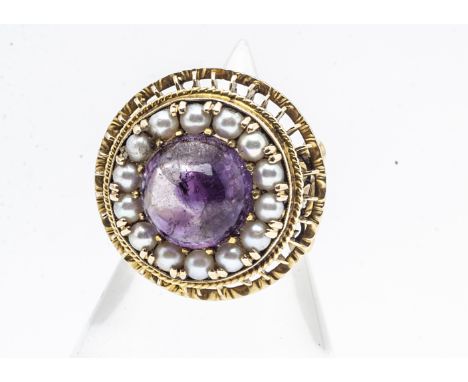 A continental amethyst and seed pearl yellow metal dress ring, the circular cabochon amethyst surrounded by half cut pearls w