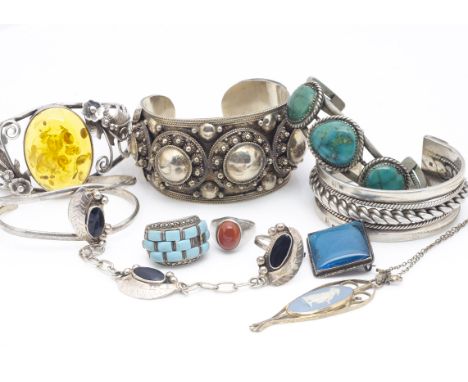 Five silver bangles, including an amber example with floral decoration, another in turquoise, two Middle Eastern examples, a 