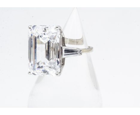 A continental 10k gold synthetic moissanite dress ring, the baguette cut stone in four claw setting with baguette cut shoulde