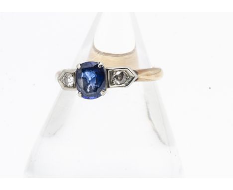 An Art Deco sapphire and diamond three stone dress ring,  the oval mixed cut claw set sapphire flanked by two old cut diamond