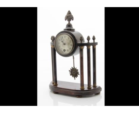 A late 19th Century mantle clock, drum 30 hour movement in wooden surround having vase and flower finial, supported on six co