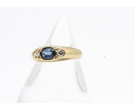 An 18ct gold sapphire and diamond three stone ring, the navette shaped setting with oval mixed cut sapphire flanked by a pair