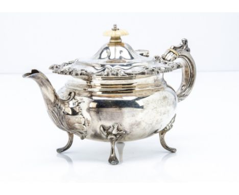 A late Victorian silver bachelors teapot by J &amp; T, floral design to upper rim and on four supports, with carved ivory fin