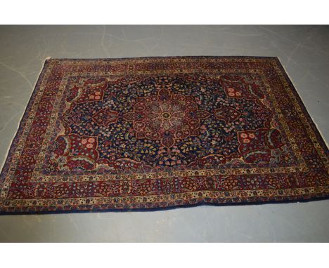 A Heriz carpet, with indigo ground and central foliate medallion enclosed by foliate meanders, contained within a repeating f