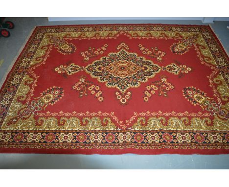 A 20th Century machine-made wool carpet, with central foliate medallion, enclosed by palmette spandrels, contained within a r