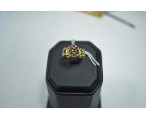 19th Century emerald and ruby cluster ring, in scrolling mount and shank, stamped '18ct'.