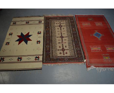 Three Kelim rugs, the first with madder ground and central medalling, contained within a geometric border, 203 x 105cms; anot