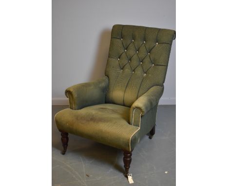A 20th Century easy armchair, with rectangular deep button back and scroll over arms, raised on a padded seat and turned legs