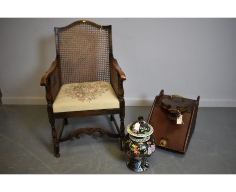 An Edwardian mahogany Bergere, with arched top rail and canework back and sides, raised on turned legs, united by stretchers;