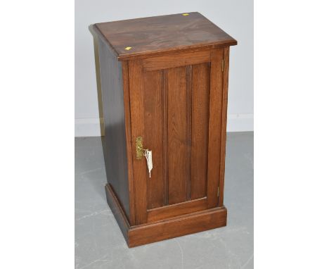 A 20th Century mahogany bedside cabinet, the rectangular top above a cupboard door, enclosing a single shelf, raised on a pli