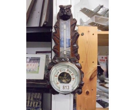 A vintage oak Black Forest barometer depicting an owl with glass eyes.
