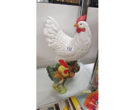 A large ceramic hen and a small cockerel.