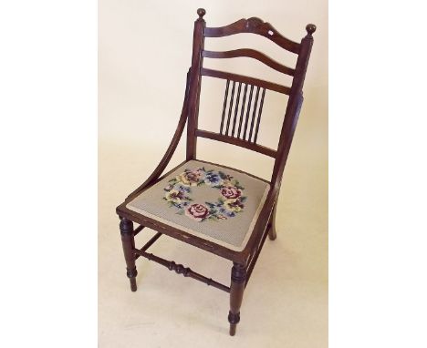 An Edwardian mahogany nursing chair with floral tapestry seat