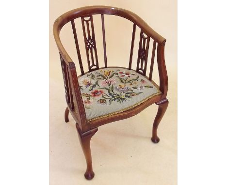 An Edwardian slat back mahogany bergere chair with tapestry seat